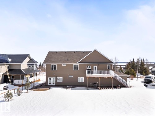 The property features a spacious exterior with a raised deck, a walk-out patio, and a large yard - 1513 Horseshoe Bay Estates, Cold Lake, AB - Outdoor With Deck Patio Veranda