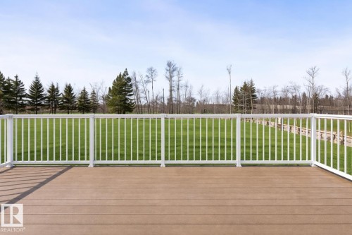 The property features a spacious deck with a composite surface and white railings, overlooking a verdant lawn - 1513 Horseshoe Bay Estates, Cold Lake, AB - Outdoor With Deck Patio Veranda