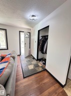 Entryway featuring a mixed tile floor, a built-in coat closet, wood-finish flooring, and a contemporary flush-mount ceiling light - 