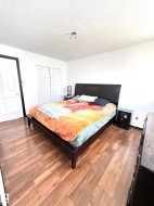 Spacious room featuring wood-finish flooring, white painted walls, and a two-panel bifold closet door - 