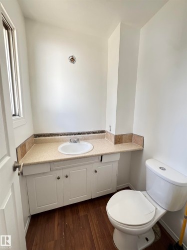 Bathroom featuring a white vanity with an integrated sink, a light-colored countertop, and a tiled backsplash - 45 Lambert Crescent, St. Albert, AB - Indoor Photo Showing Bathroom