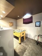 Carpeted recreational space featuring recessed lighting and a foosball table - 