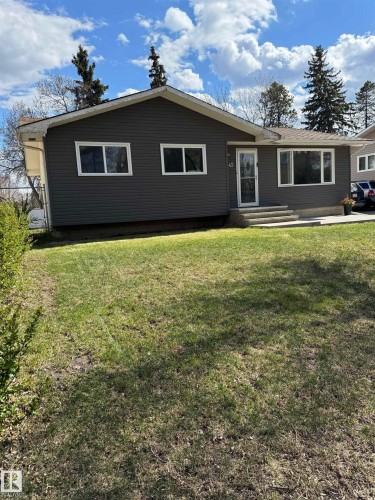 Ranch-style residence featuring dark gray horizontal siding, white trim, and a prominent front lawn - 45 Lambert Crescent, St. Albert, AB - Outdoor