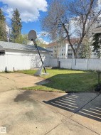 Expansive concrete patio area with a chain-link fence defining the property perimeter - 