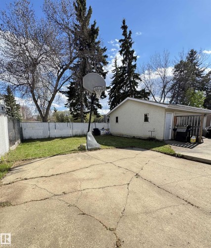 Spacious backyard featuring a concrete patio area, a grass lawn, and mature trees - 45 Lambert Crescent, St. Albert, AB - Outdoor