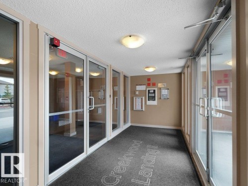 Entryway featuring multiple glass panel doors, recessed dome lighting, a textured ceiling, and a grey floor mat - 216 5390 Chappelle Road, Edmonton, AB - Indoor Photo Showing Other Room