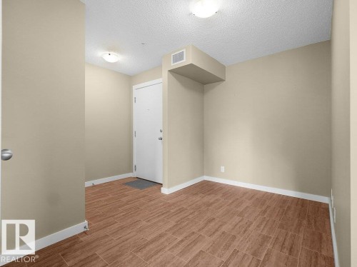 Entryway featuring wood-look tile flooring, light neutral wall paint, and white trim - 216 5390 Chappelle Road, Edmonton, AB - Indoor Photo Showing Other Room