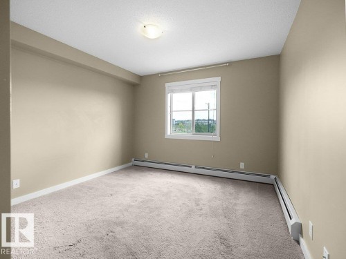 Neutral-toned room featuring light beige walls and soft carpet flooring - 216 5390 Chappelle Road, Edmonton, AB - Indoor Photo Showing Other Room