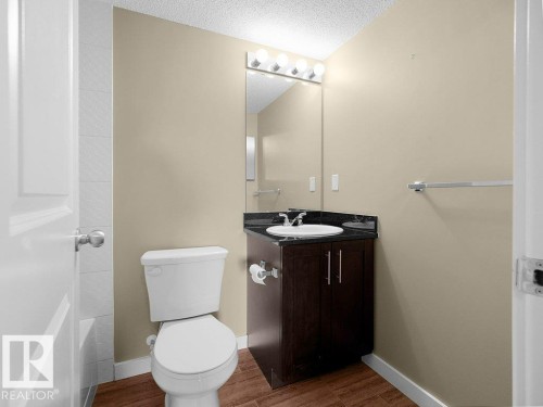 Bathroom featuring a dark wood-finish vanity with a black countertop and an undermount sink - 216 5390 Chappelle Road, Edmonton, AB - Indoor Photo Showing Bathroom