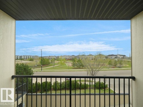 Balcony featuring black metal railings and a textured ceiling - 216 5390 Chappelle Road, Edmonton, AB - Outdoor With Balcony With View