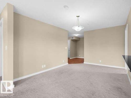 Spacious room with neutral wall tones and textured carpeting - 216 5390 Chappelle Road, Edmonton, AB - Indoor Photo Showing Other Room