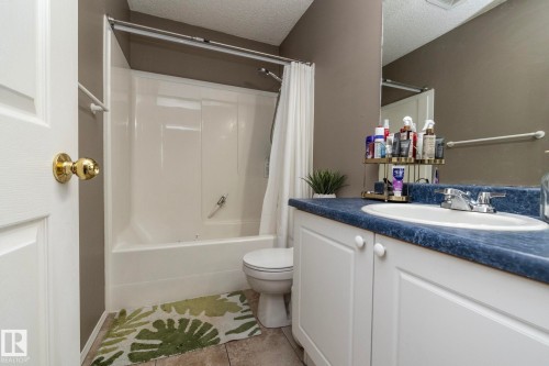 Bathroom featuring a white vanity with paneling, a blue countertop, a drop-in sink, and a chrome faucet - 9112 166 Avenue, Edmonton, AB - Indoor Photo Showing Bathroom