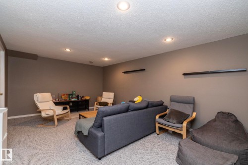 Carpeted recreation room featuring recessed lighting, neutral wall tones, and a built-in media console - 9112 166 Avenue, Edmonton, AB - Indoor