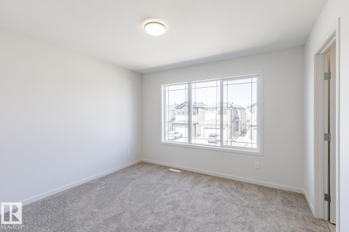 Neutral color palette with light gray carpet and white walls - 3613 Triomphe Boulevard N, Beaumont, AB - Indoor Photo Showing Other Room