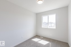 Room featuring a double-pane window, flush-mount ceiling light, light gray wall paint, and gray carpet flooring - 