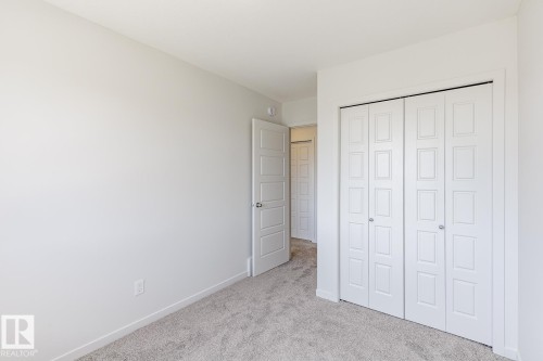 Neutral-toned room featuring a soft gray carpet, white walls, and bright white trim - 3613 Triomphe Boulevard N, Beaumont, AB - Indoor