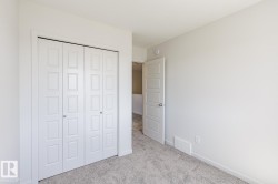 Bedroom featuring light grey carpeting, white walls, and white trim - 