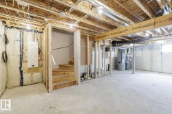 Unfinished basement presenting open joist ceilings, exposed framing, and a concrete floor - 