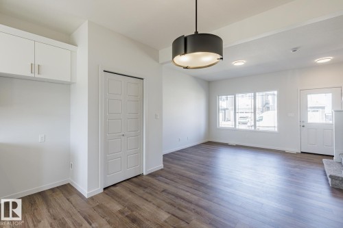 Open-concept living space with wood-finish flooring - 3613 Triomphe Boulevard N, Beaumont, AB - Indoor Photo Showing Other Room