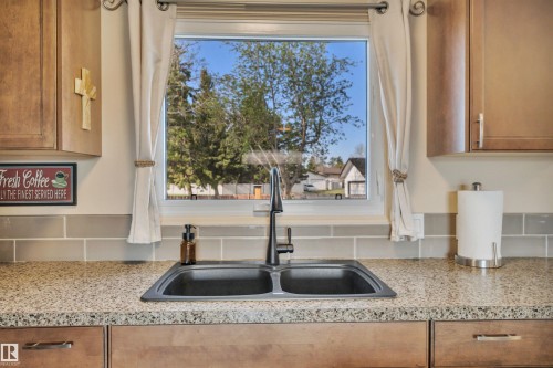 Kitchen sink with a dual basin, a matte black faucet, and a window above - 112 Oak Drive, Wetaskiwin, AB - Indoor Photo Showing Kitchen With Double Sink