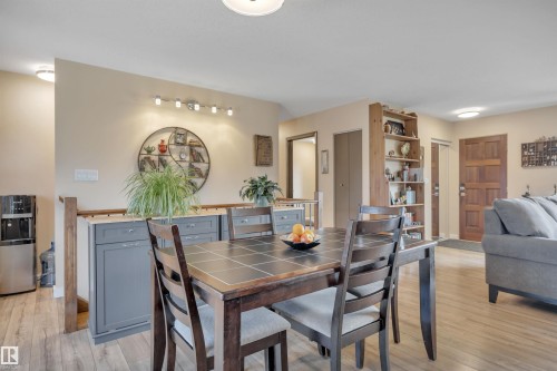 Dining area featuring a dark wood-finish table with a tiled surface, accompanied by upholstered chairs - 112 Oak Drive, Wetaskiwin, AB - Indoor Photo Showing Dining Room