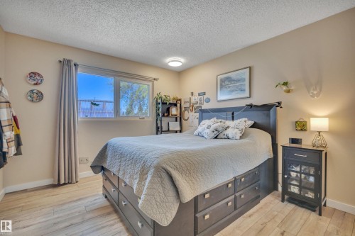 Bedroom featuring light wood-finish flooring, a double window, neutral wall paint, white trim, and a ceiling-mounted light fixture - 112 Oak Drive, Wetaskiwin, AB - Indoor Photo Showing Bedroom