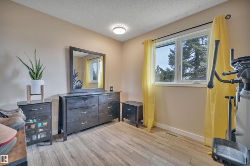 Room featuring wood-finish flooring, a light neutral wall color, and a window with white trim - 112 Oak Drive, Wetaskiwin, AB - Indoor Photo Showing Gym Room