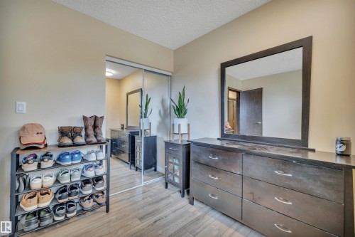Light-toned walls complement wood-finish flooring in this room featuring a ceiling with textured finish - 112 Oak Drive, Wetaskiwin, AB - Indoor Photo Showing Other Room