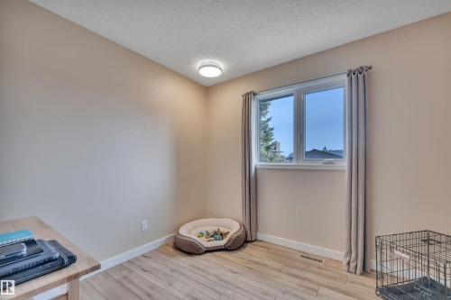Room featuring wood-finish flooring, a double window with light-colored drapes, and a ceiling-mounted light fixture - 112 Oak Drive, Wetaskiwin, AB - Indoor Photo Showing Other Room