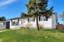 White siding exterior with black window shutters and a mature evergreen tree - 112 Oak Drive, Wetaskiwin, AB  - Outdoor 
