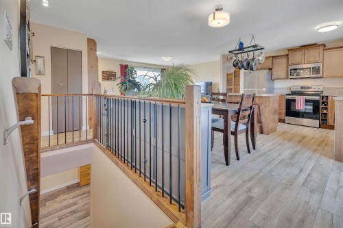 Open concept living space featuring wood-finish flooring, a kitchen with stainless steel appliances, light wood cabinetry, and a dining area - 112 Oak Drive, Wetaskiwin, AB - Indoor Photo Showing Other Room