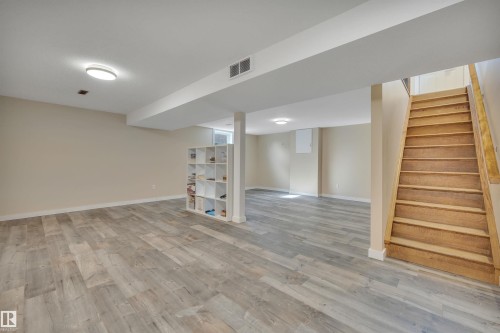 Spacious finished lower level featuring wood-finish flooring, recessed lighting, neutral wall tones, and a built-in shelving unit - 112 Oak Drive, Wetaskiwin, AB - Indoor