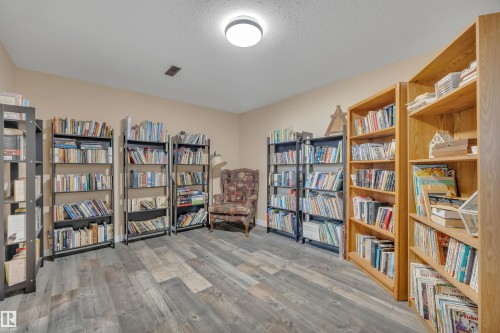 Versatile room featuring wood-finish flooring, neutral wall paint, a flush-mount ceiling light, and ample shelving for storage - 112 Oak Drive, Wetaskiwin, AB - Indoor