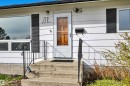 White horizontal siding exterior with a wood-panel front door - 112 Oak Drive, Wetaskiwin, AB  - Outdoor With Exterior 