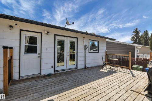 Expansive wood deck with a natural finish, featuring a wood railing with black metal balusters - 112 Oak Drive, Wetaskiwin, AB - Outdoor With Deck Patio Veranda With Exterior