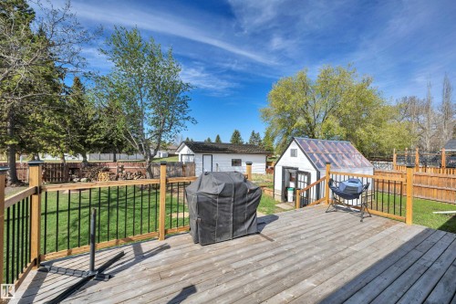 Spacious outdoor deck with natural wood planks and black metal railings - 112 Oak Drive, Wetaskiwin, AB - Outdoor With Deck Patio Veranda With Exterior