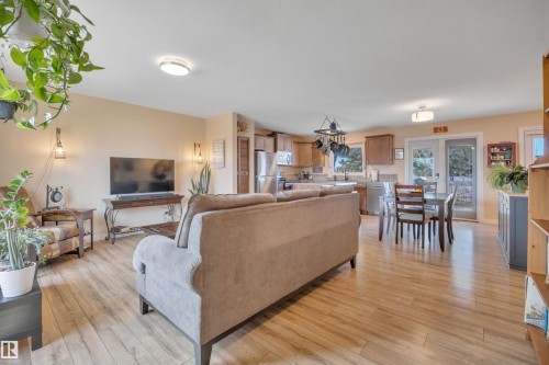 Open-concept living space featuring wood-finish flooring, recessed lighting, and a kitchen with stainless steel appliances - 112 Oak Drive, Wetaskiwin, AB - Indoor Photo Showing Living Room