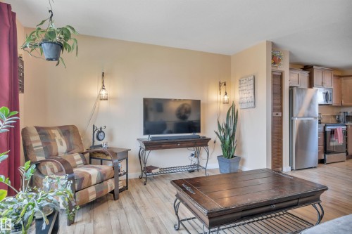 Open-concept living area featuring wood-finish flooring, warm-toned walls, and recessed lighting - 112 Oak Drive, Wetaskiwin, AB - Indoor Photo Showing Living Room