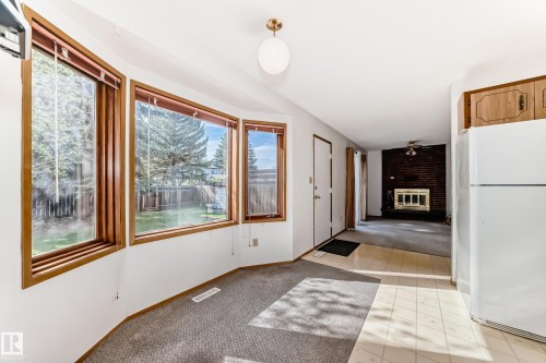 Bay window area featuring wood-framed windows, carpet flooring, and a ceiling-mounted light fixture - 9528 189 Street, Edmonton, AB - Indoor Photo Showing Other Room