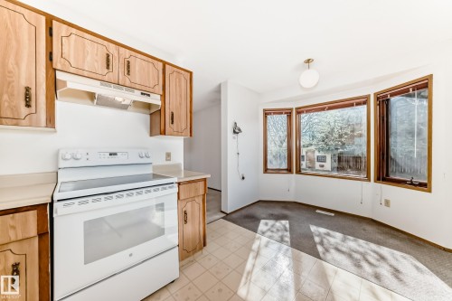 Kitchen featuring wood-finish cabinetry, white appliances, and light-toned countertops - 9528 189 Street, Edmonton, AB - Indoor Photo Showing Kitchen