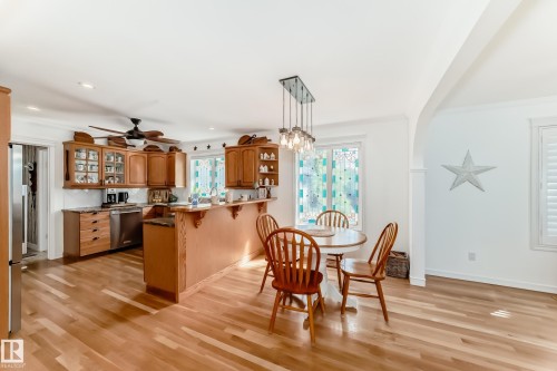 Kitchen and dining area featuring wood-finish flooring - 11115 44 Street, Edmonton, AB - Indoor