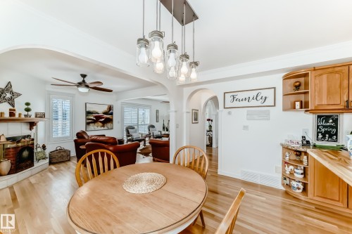 Dining area with wood-finish flooring and a contemporary pendant light fixture - 11115 44 Street, Edmonton, AB - Indoor Photo Showing Dining Room