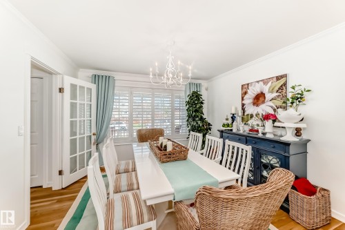 Dining area featuring wood-finish flooring, white walls, and crown molding - 11115 44 Street, Edmonton, AB - Indoor Photo Showing Dining Room