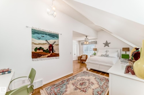 Vaulted ceilings featuring a flush-mount chandelier, natural wood-finish flooring, and white walls - 11115 44 Street, Edmonton, AB - Indoor Photo Showing Other Room