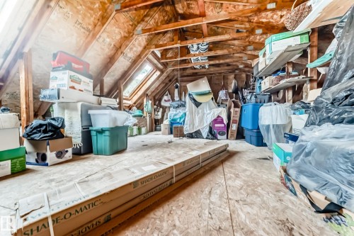 Spacious attic area featuring exposed wood beams, wood-finish flooring, and two skylight windows - 11115 44 Street, Edmonton, AB - Indoor