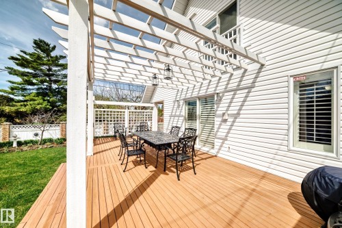 Expansive wood deck with a white slatted pergola, featuring two hanging lanterns - 11115 44 Street, Edmonton, AB - Outdoor With Deck Patio Veranda