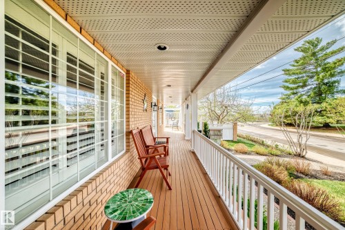 Covered front porch featuring wood-finish decking, white railing, and recessed lighting - 11115 44 Street, Edmonton, AB - Outdoor With Deck Patio Veranda With Exterior