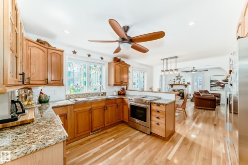 Kitchen featuring wood cabinetry, granite countertops, and stainless steel appliances - 11115 44 Street, Edmonton, AB - Indoor Photo Showing Kitchen With Double Sink