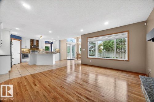 Open-concept living area with hardwood flooring and a large picture window - 11824 13 Avenue, Edmonton, AB - Indoor Photo Showing Kitchen