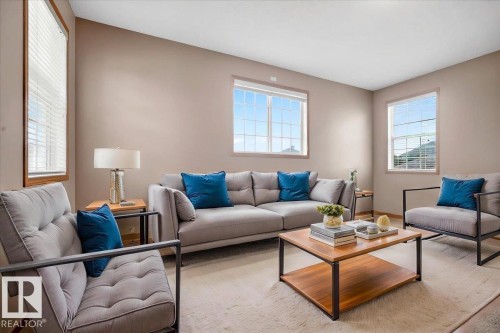 Open-concept living area with neutral wall tones and large windows featuring white blinds - 11824 13 Avenue, Edmonton, AB - Indoor Photo Showing Living Room